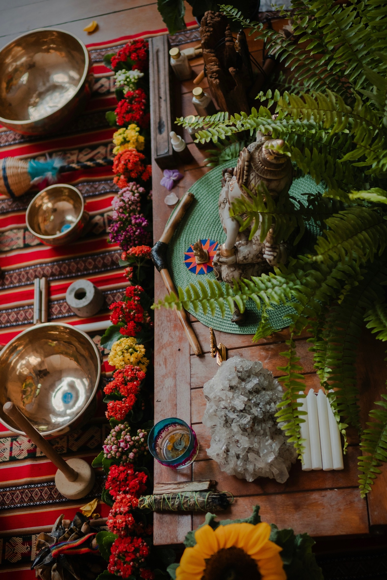 Overhead altar with brass singing bowls, crystals, ferns and candles for sound healing